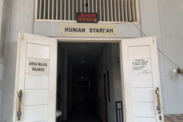 A hallway with a sign reading "HUNIAN SYARI'AH" and a digital clock displaying "09:44:48".