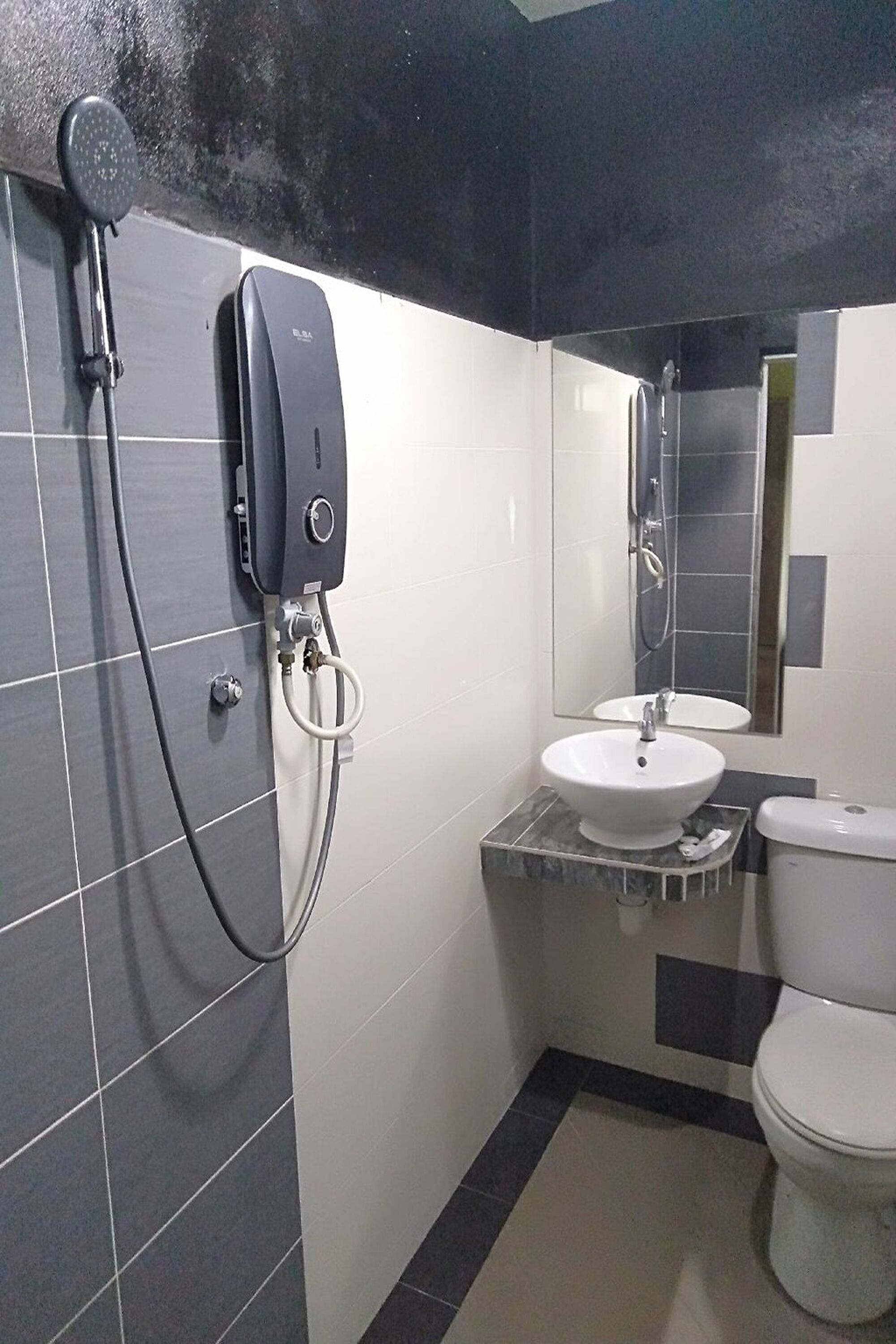 Un baño con diseño moderno, que incluye un lavamanos, inodoro y cabezal de ducha de mano.