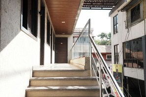 A staircase leading to a hotel entrance with a wooden ceiling and glass railings. - Hotel Sai Executive Near Holy Cross Church Mahabaleshwar (Mahabaleshwar)