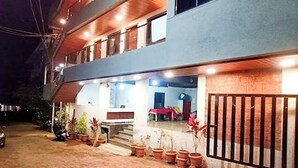 A two-story building with a balcony, potted plants, and a gated entrance. - Hotel Sai Executive Near Holy Cross Church Mahabaleshwar (Mahabaleshwar)