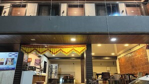 A hotel lobby with a reception desk, seating area, and a car parked outside. - Hotel Sai Executive Near Holy Cross Church Mahabaleshwar (Mahabaleshwar)