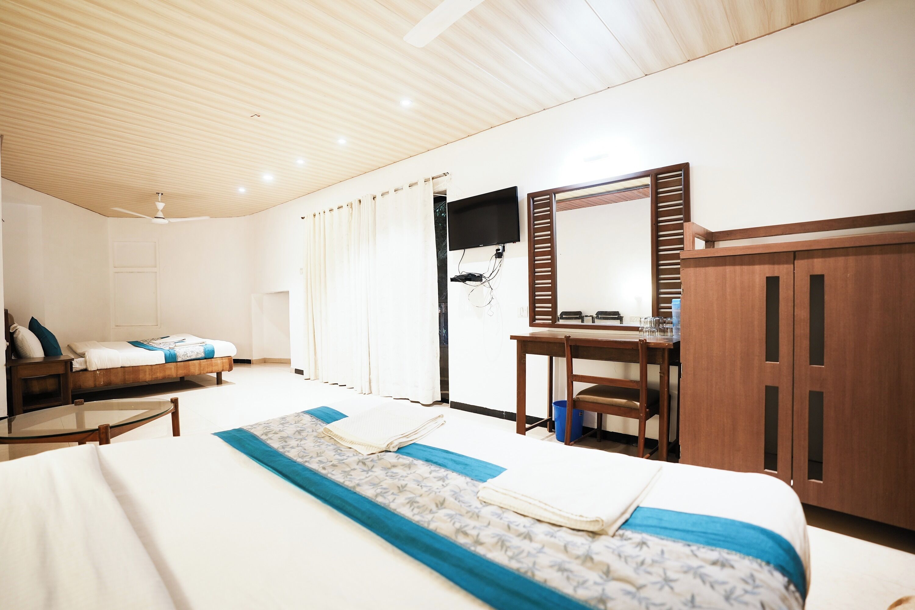 A hotel room with a bed, a desk, a chair, and a wardrobe.