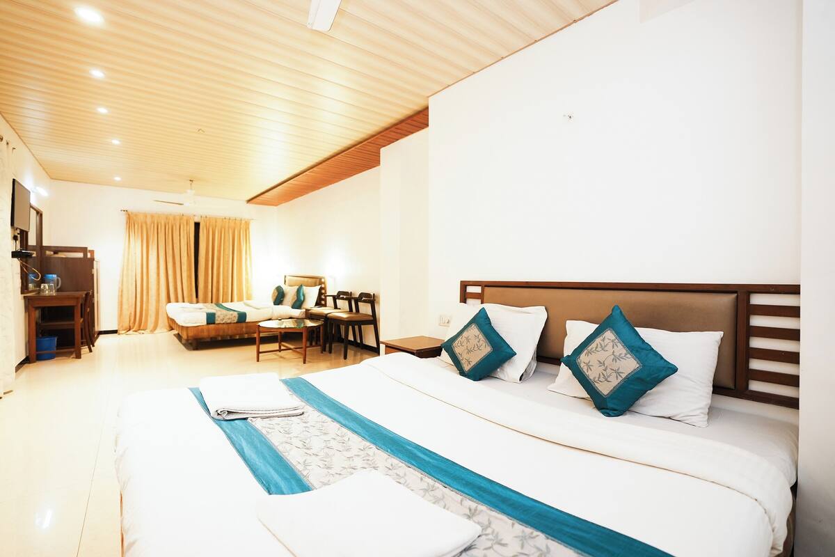 Une chambre d’hôtel avec un grand lit, un bureau et une chaise.