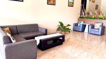 A modern lobby with a grey sofa, a small coffee table, and a blue armchair.