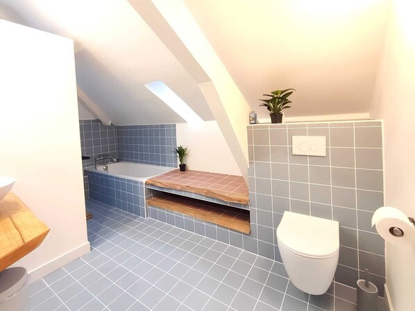 Un baño moderno con bañera, inodoro y lavamanos.