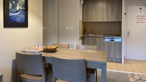 A modern kitchen with grey cabinets, a built-in oven, and a sink. - Stunning Beachfront Apartment with Pool, WiFi, and Balcony in Perros-Guirec (Perros-Guirec)