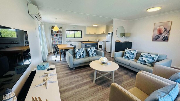 Een moderne woonkamer met een bank, salontafel en televisie.