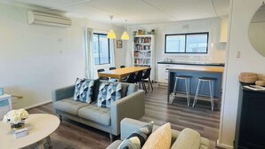 Een modern appartement met een woonkamer, eethoek en keuken.