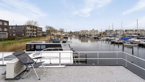 Ein Yachthafen mit vertäuten Booten, ein Gebäude mit flachem Dach und Blick auf das Wasser.