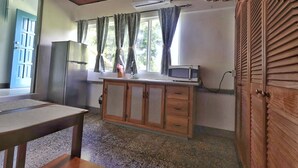 A room with a wooden cabinet, a table, a microwave, and a window with curtains. - Cozy 1-bed Apt in Whim Estate-near Scarborough (Scarborough)