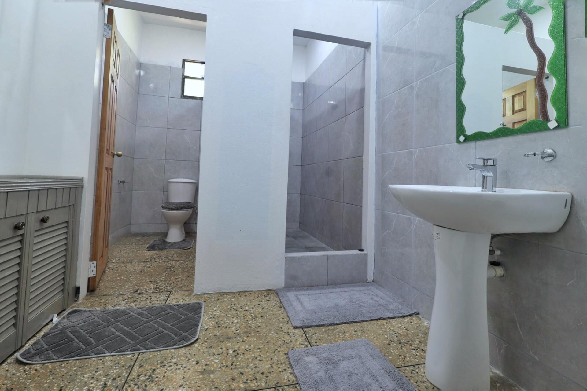 Une salle de bain avec des toilettes, une douche et un lavabo.