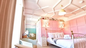 A bedroom with a bed, bedside tables, a chair, and a wall with a mural. - The Beach House (Lymington)