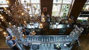 A bar area with a chandelier, wine glasses, and bottles. - The Beach House (Lymington)