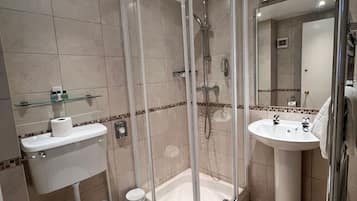 A modern bathroom with a glass-enclosed shower, a pedestal sink, and a toilet.