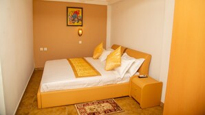 Quarto com cama, mesa de cabeceira e ventilador de teto.