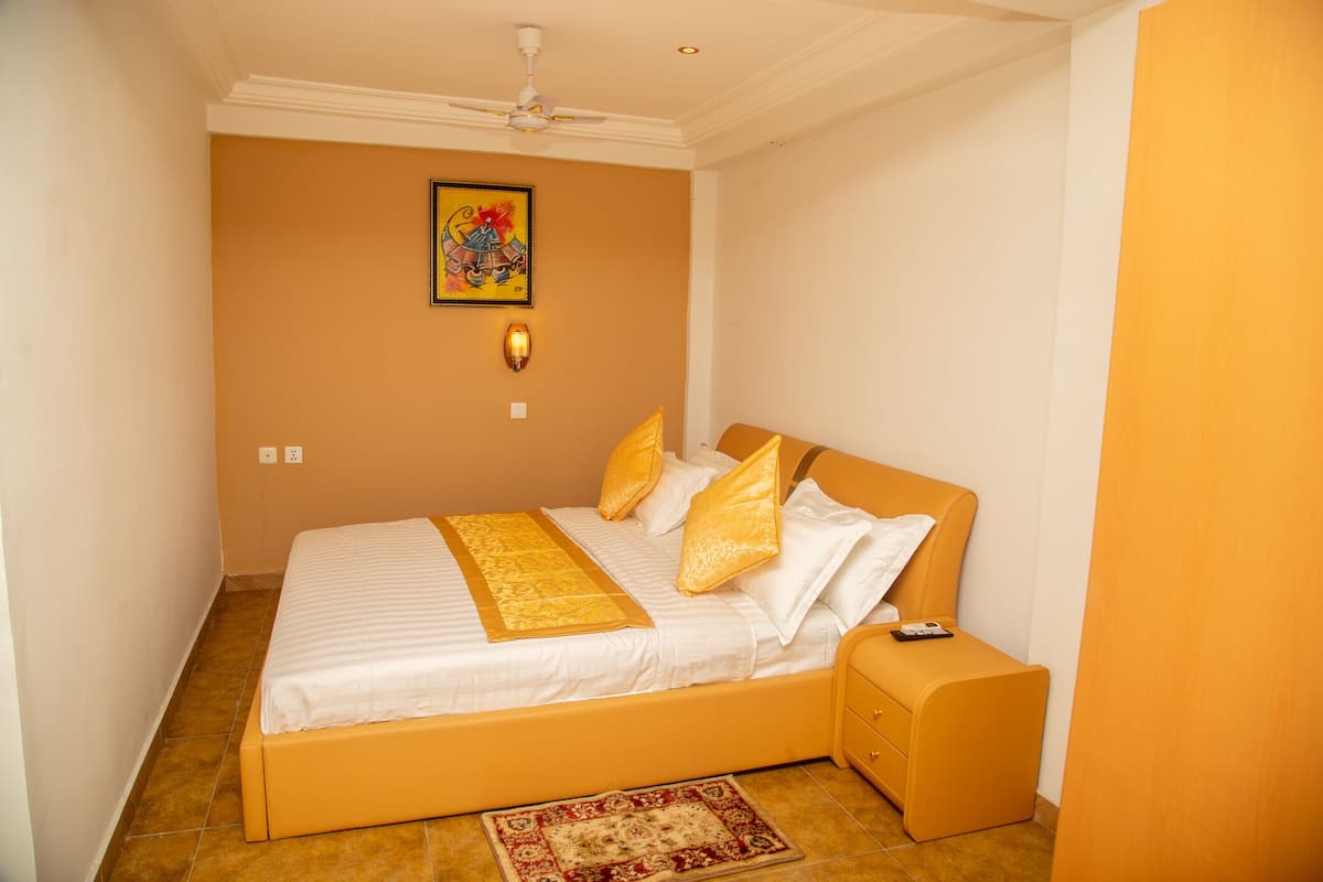 Une chambre à coucher avec un lit, une table de chevet et un ventilateur de plafond.