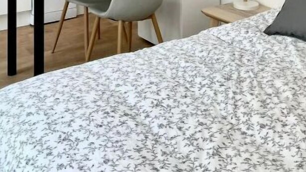 A modern kitchen with white cabinets, a wooden countertop, and a dining area with a table and chairs. - Chez Clément et Mathilde - Studio Hyper Centre (Saint-Amand-les-Eaux)