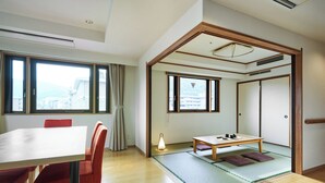 A traditional Japanese-style room with tatami flooring, a low table with tea set, and sliding doors.