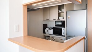 A modern kitchen with built-in appliances, a wooden countertop, and a microwave.