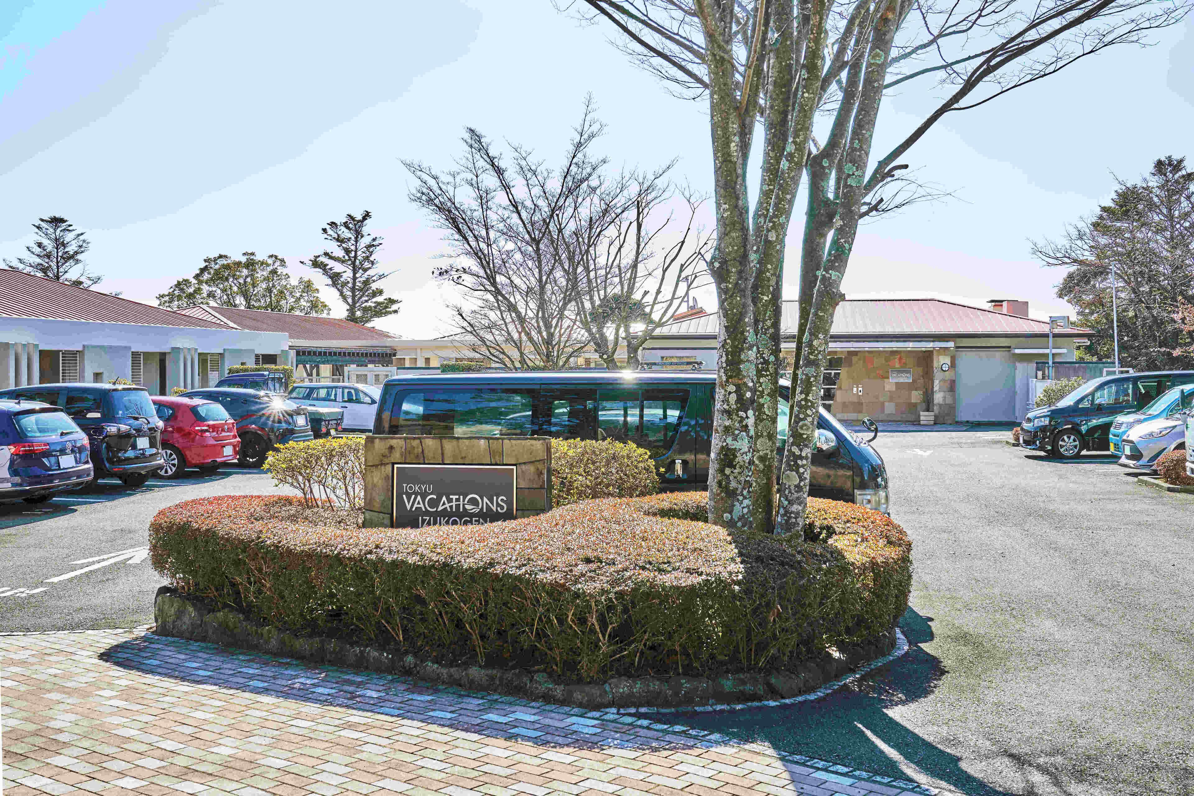 A parking area with a sign for "Tokyo Vacations IzuKogen."
