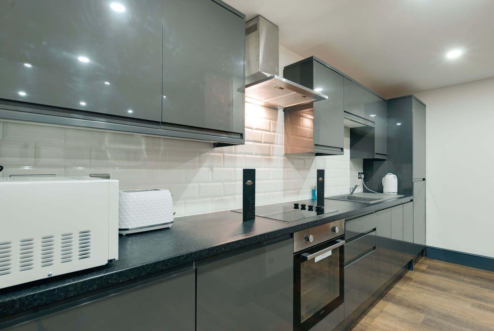 A modern kitchen with sleek cabinetry, a built-in oven, and a countertop with a toaster.