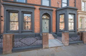 Traditional architecture meets modern charm in this corner building with large windows and a symmetrical design.