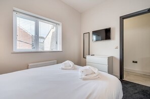 Relax in a serene space with a large bed, flat-screen TV, and a convenient bathroom.