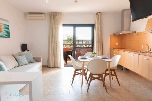 Un apartamento moderno con comedor, kitchenette y balcón con vistas.
