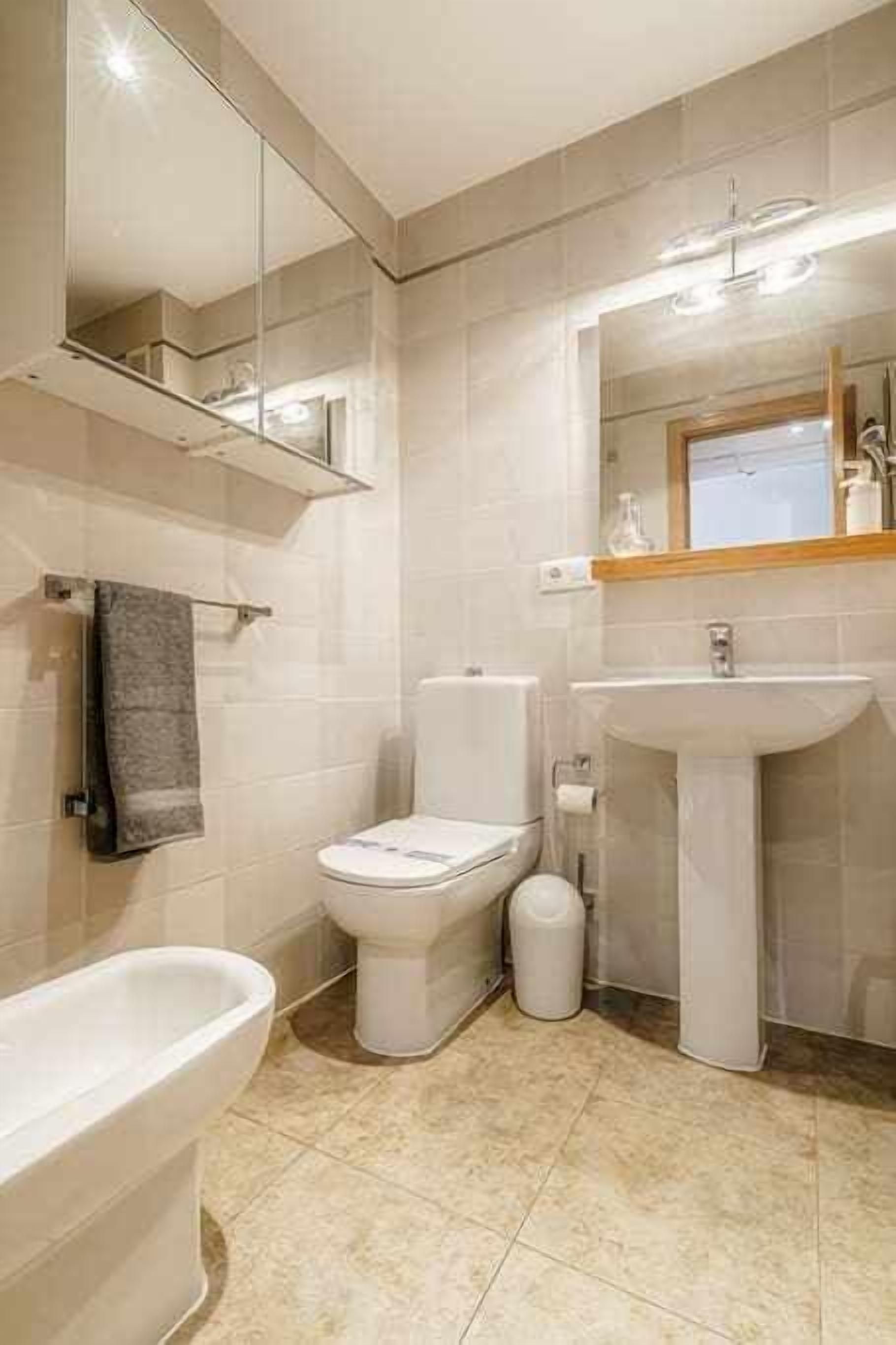 Un baño moderno con inodoro, lavamanos y bañera.