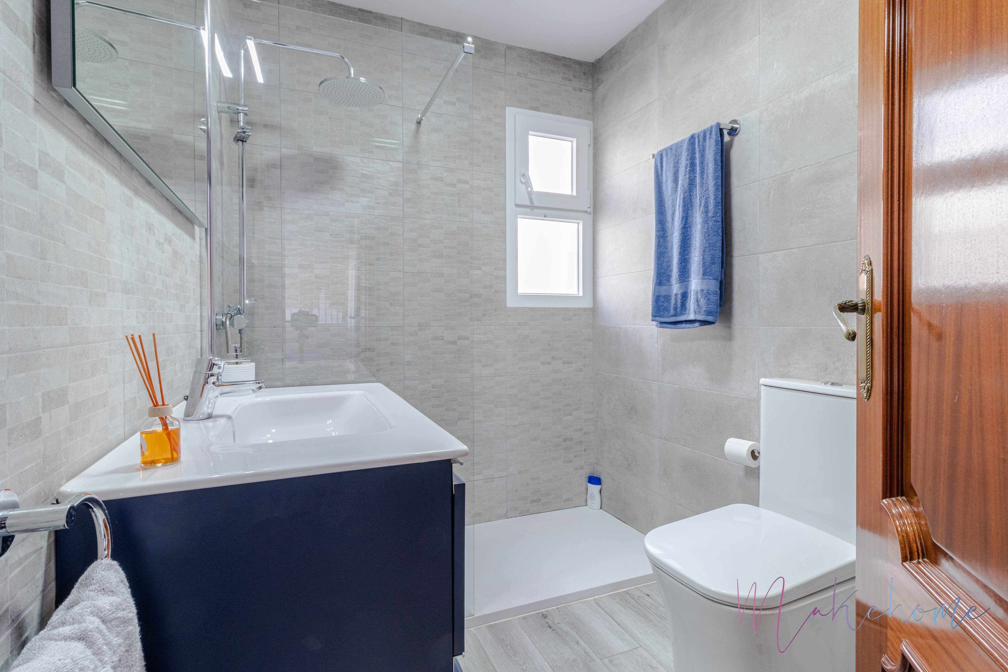 Een moderne badkamer met een bad, toilet en douche.