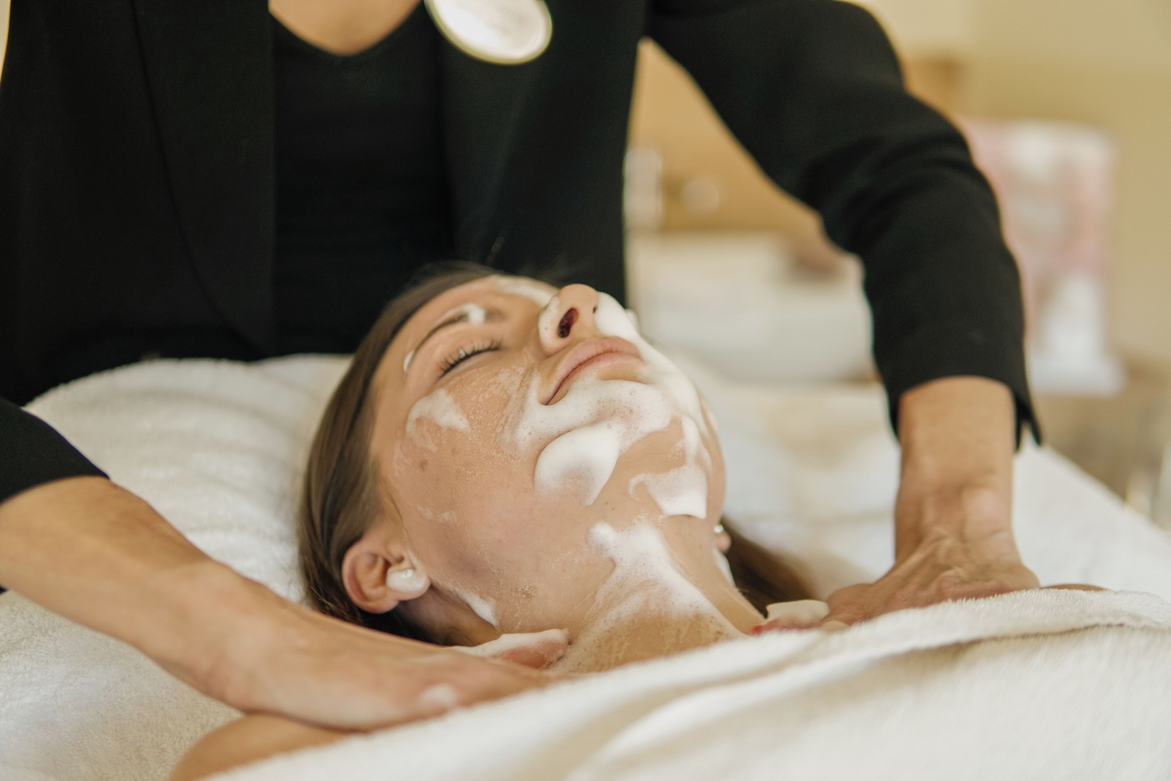 Una persona recibiendo un tratamiento facial con mascarilla.