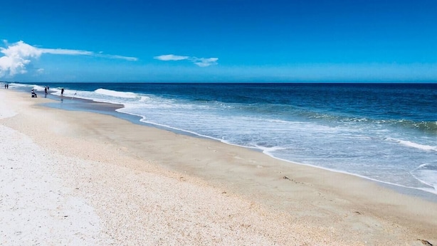 A beach with a clear sky and calm sea.