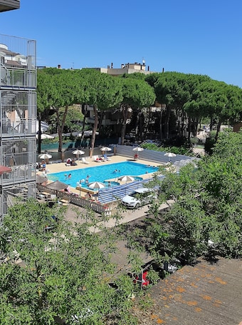 Una piscina al aire libre de temporada, sombrillas