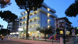 A multi-story building with balconies, a playground, and a no parking sign. - Residence Quadrifoglio (Cervia)