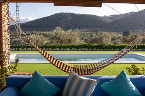 Uma rede sobre uma piscina, com vista para uma paisagem montanhosa.