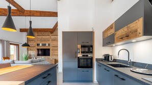 A modern kitchen with blue cabinets, a wooden island, and pendant lighting. - Appartement Ouréa 8 pers navette stations à 100m (Saint-Jean-de-Sixt)