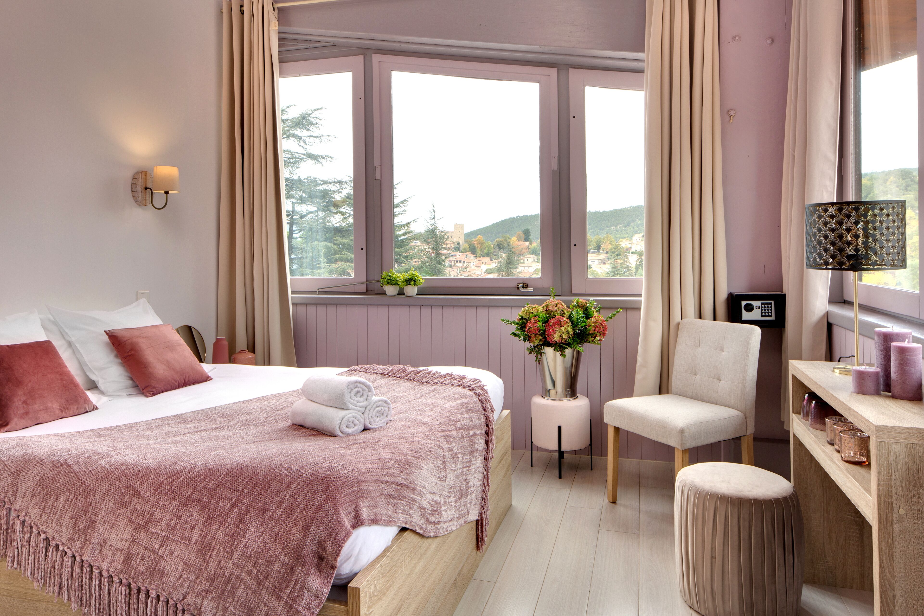 Une chambre à coucher comprenant un lit, une table de chevet, une chaise et donnant sur l’extérieur.