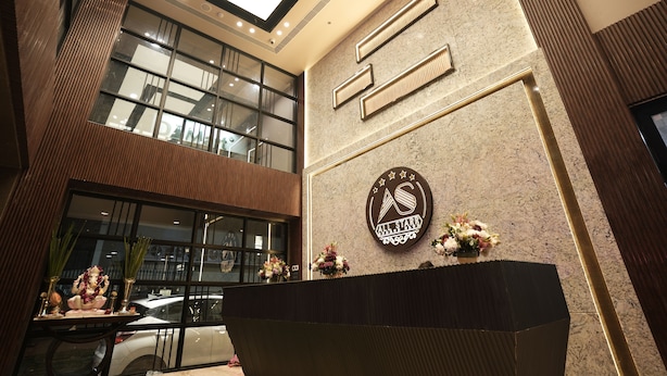 A lobby with a reception desk, a large window, and a wall-mounted logo. - All Starr Sports (Jaipur)
