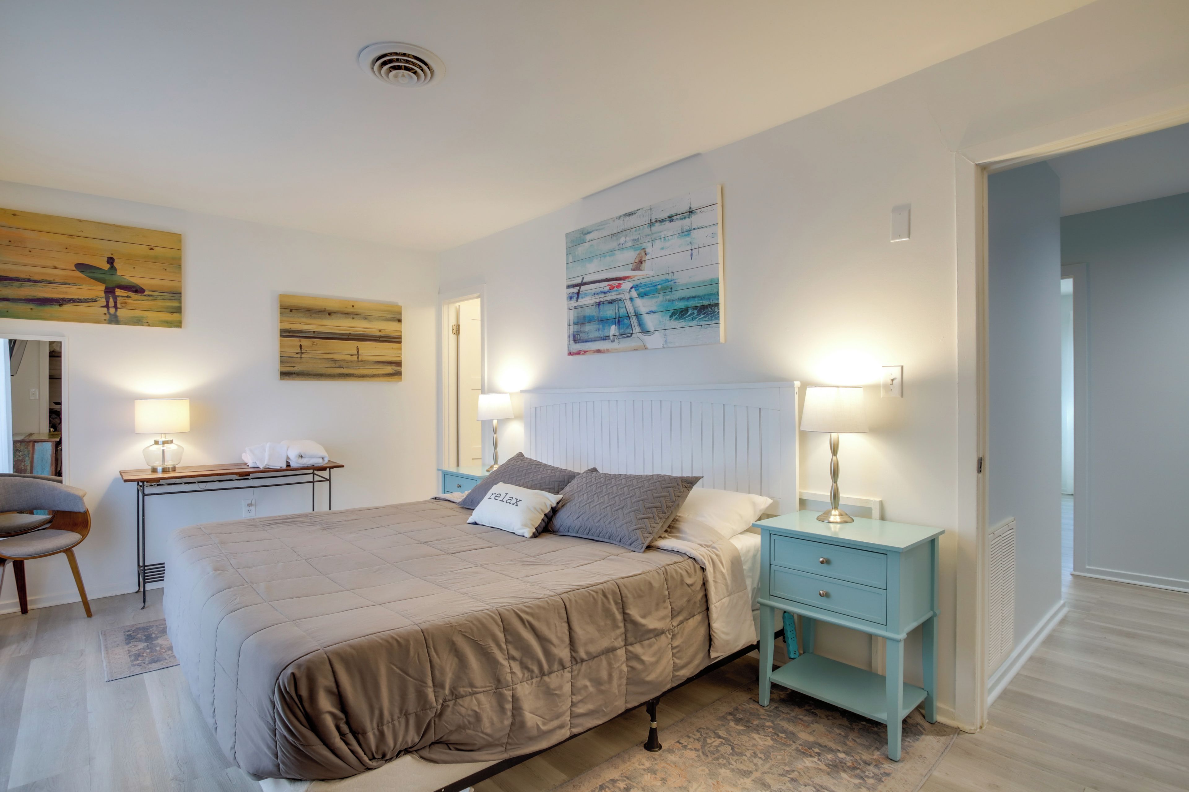 Une chambre à coucher avec un lit, des tables de chevet et des œuvres d’art accrochées aux murs.