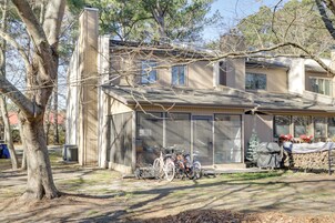 Una casa con porche cubierto, garaje y un pequeño árbol en el frente.