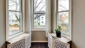 Ein Eckzimmer mit Erkerfenster mit Blick auf eine Straße.