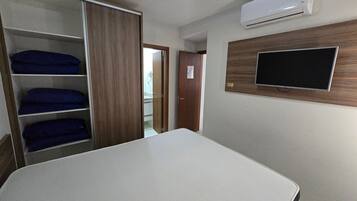 Une chambre équipée d’un lit, d’une armoire, d’un climatiseur et d’un téléviseur.