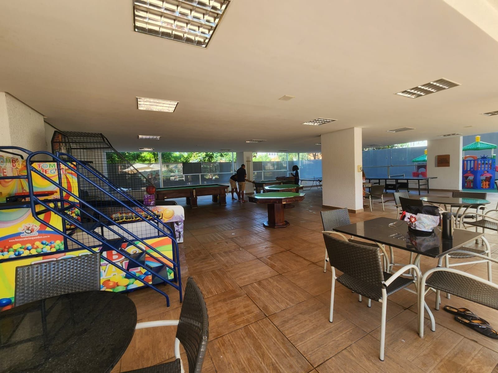 A recreational area with a pool table, billiards, and a children's play area with a colorful slide.
