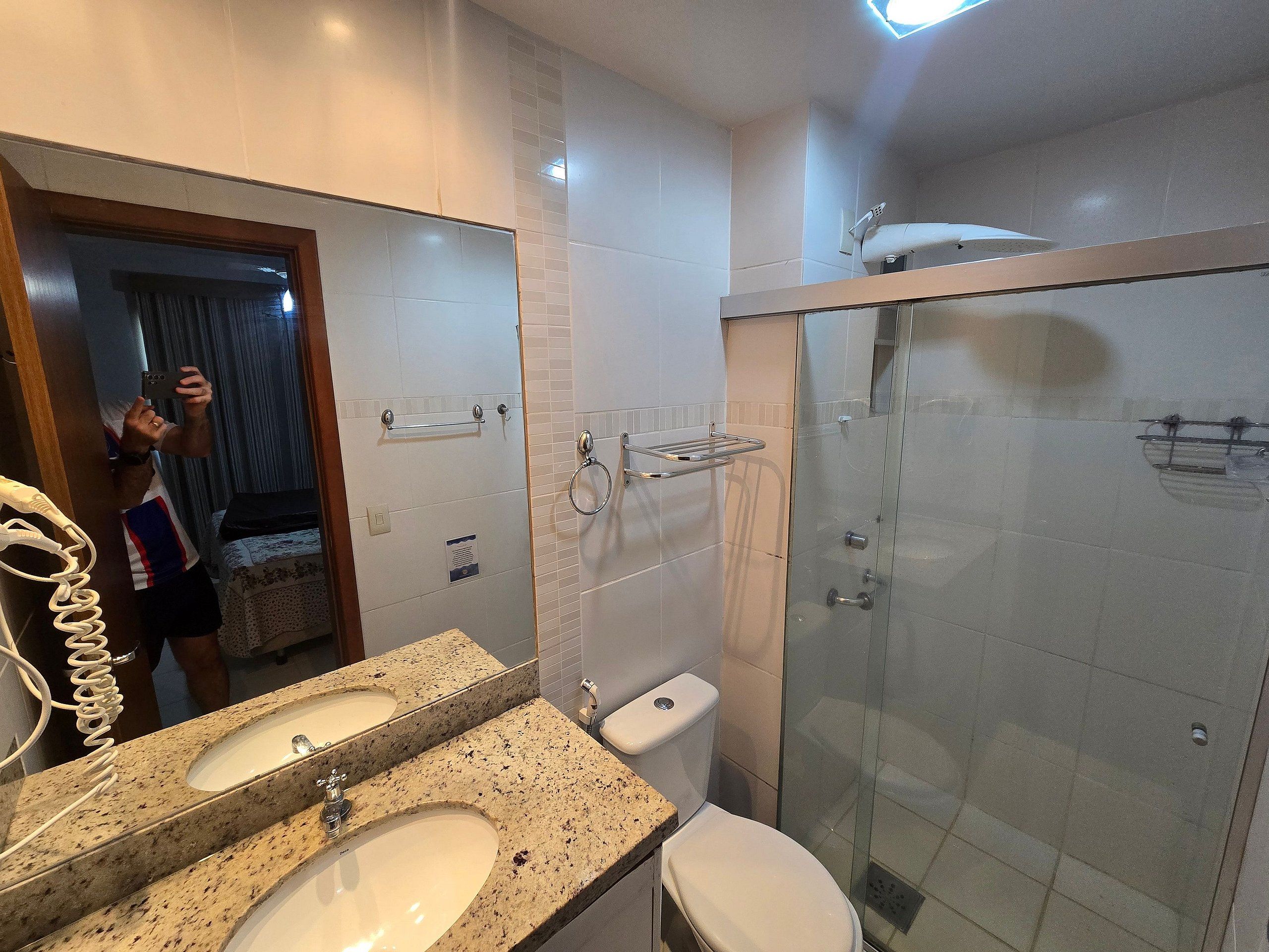 Un baño moderno con lavamanos doble, inodoro y ducha con cerramiento de vidrio.