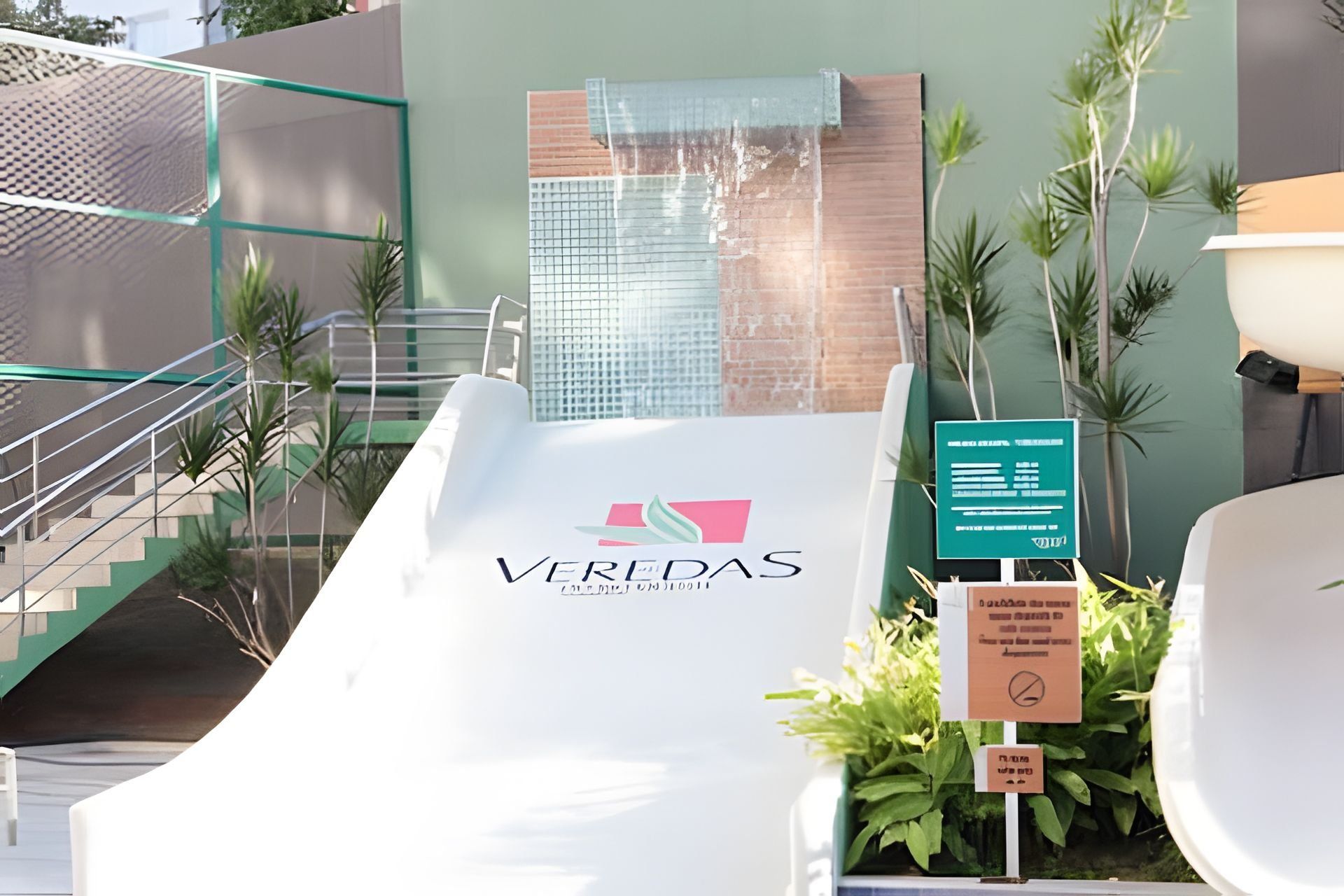 Una entrada de hotel moderna con fachada de vidrio, una escalera y un cartel.