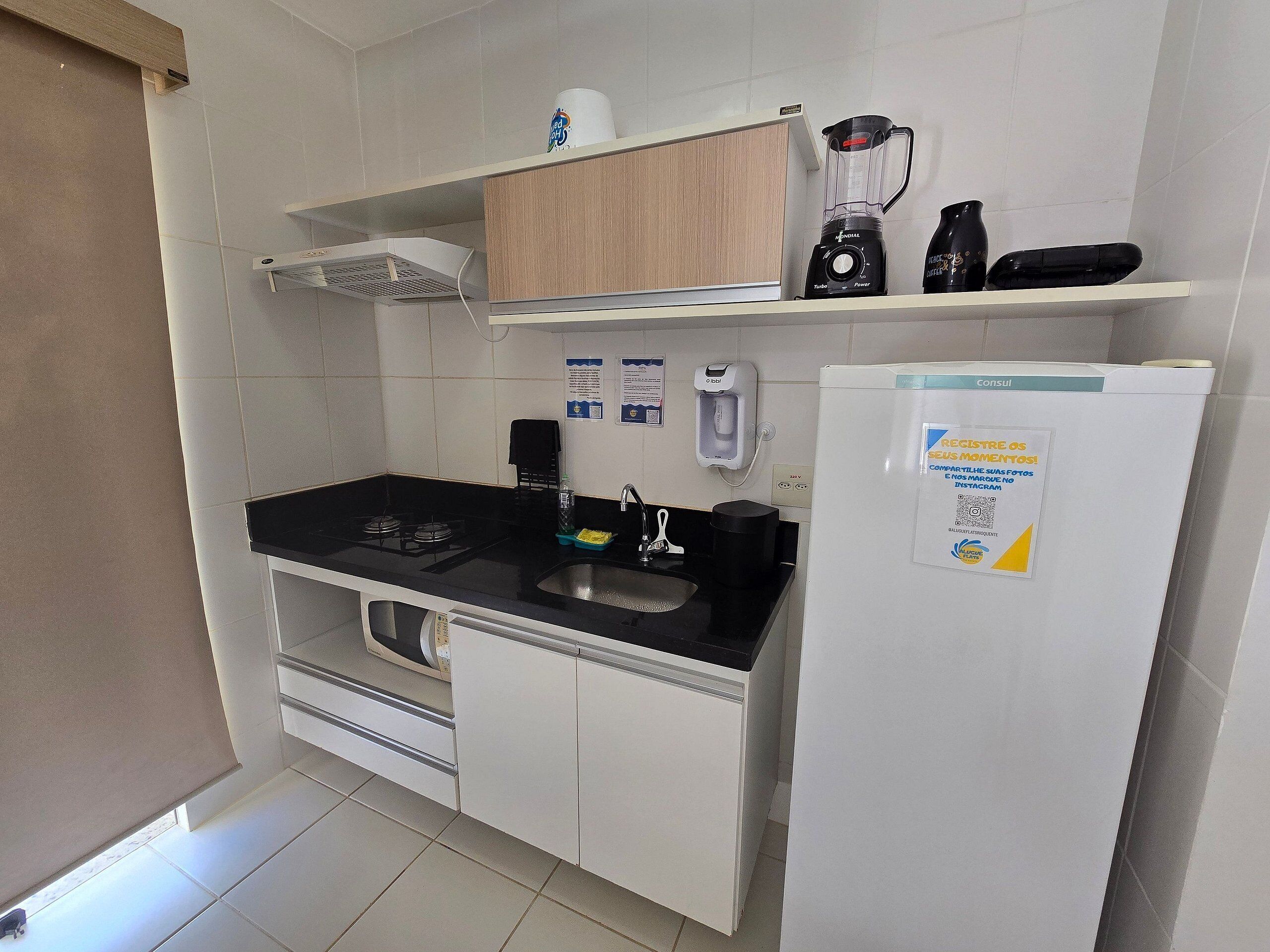 Una cocina compacta con un lavabo, estufa y refrigerador.