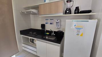 Una cocina compacta con un lavabo, estufa y refrigerador.