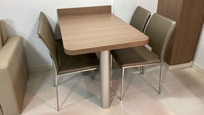 A dining area with a rectangular table and four chairs. - Aptos Rio Quente - ótima área de lazer (Rio Quente)