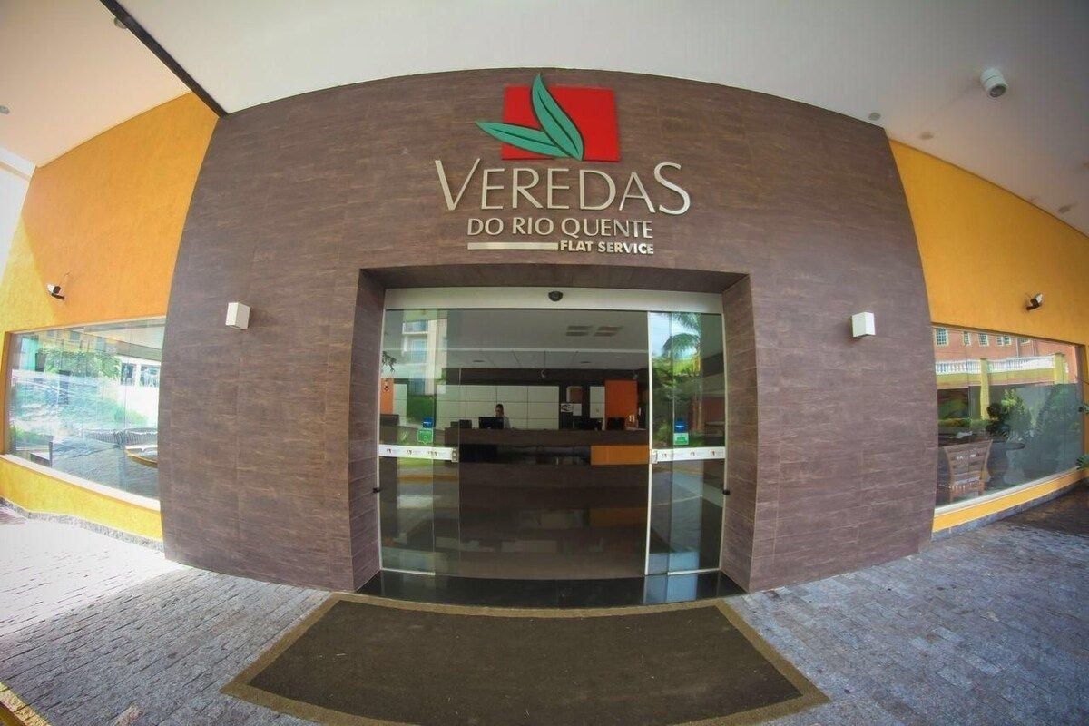 The entrance to Veredas do Rio Quente with a modern design, featuring a curved facade and glass doors.