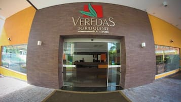 The entrance to Veredas do Rio Quente with a modern design, featuring a curved facade and glass doors.